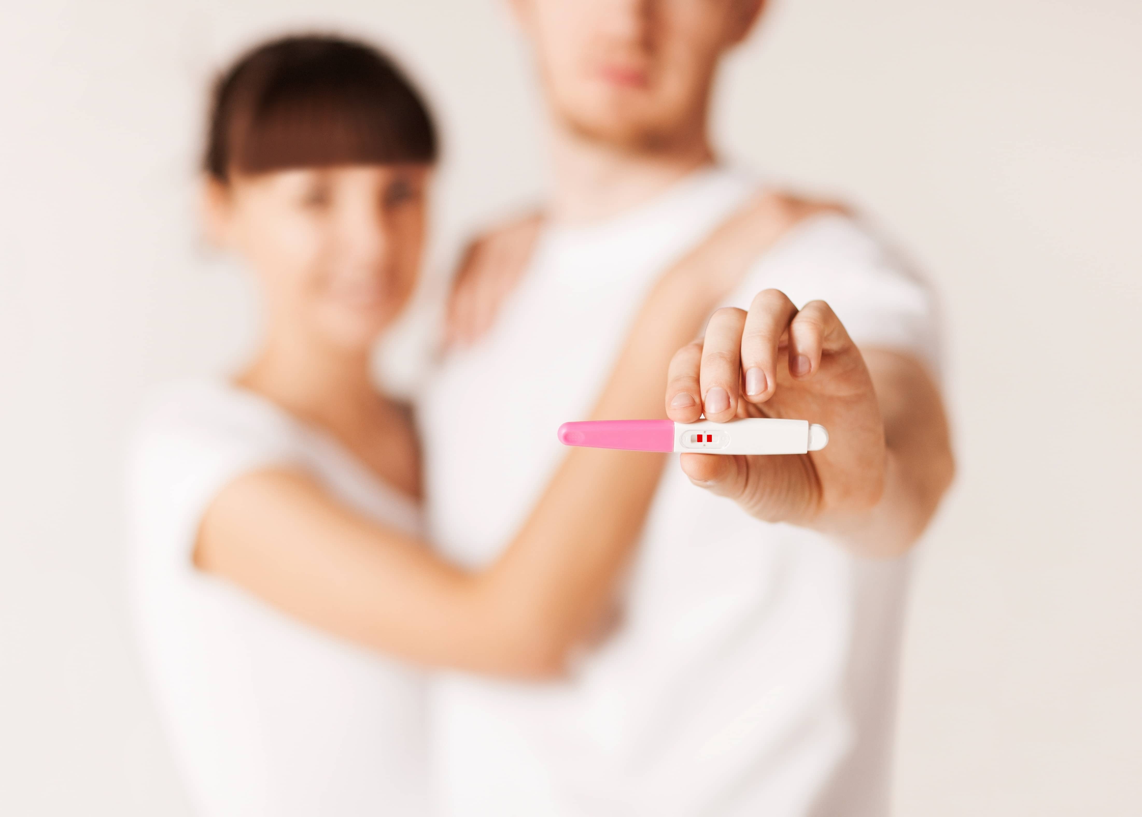 close up of woman and man hands with pregnancy test